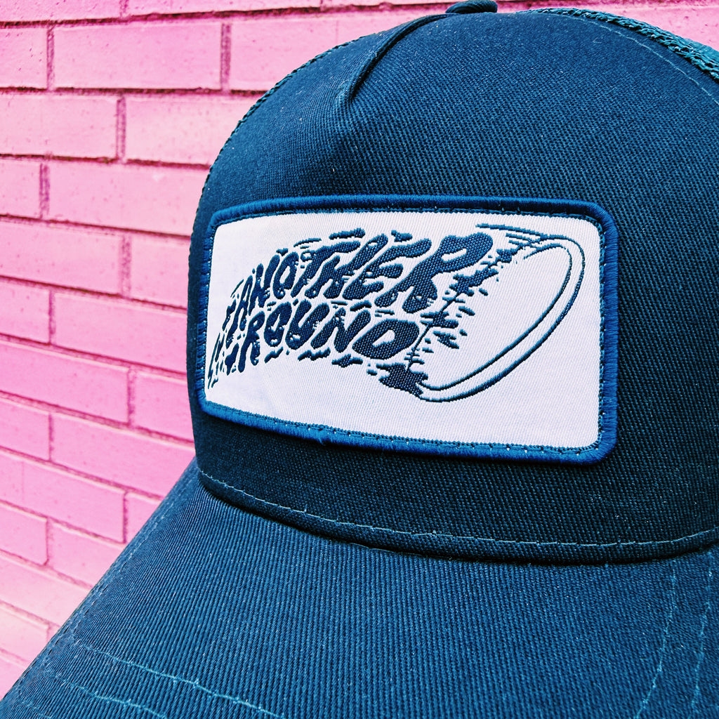Close-up of Another Round Shred Trucker hat in navy and navy